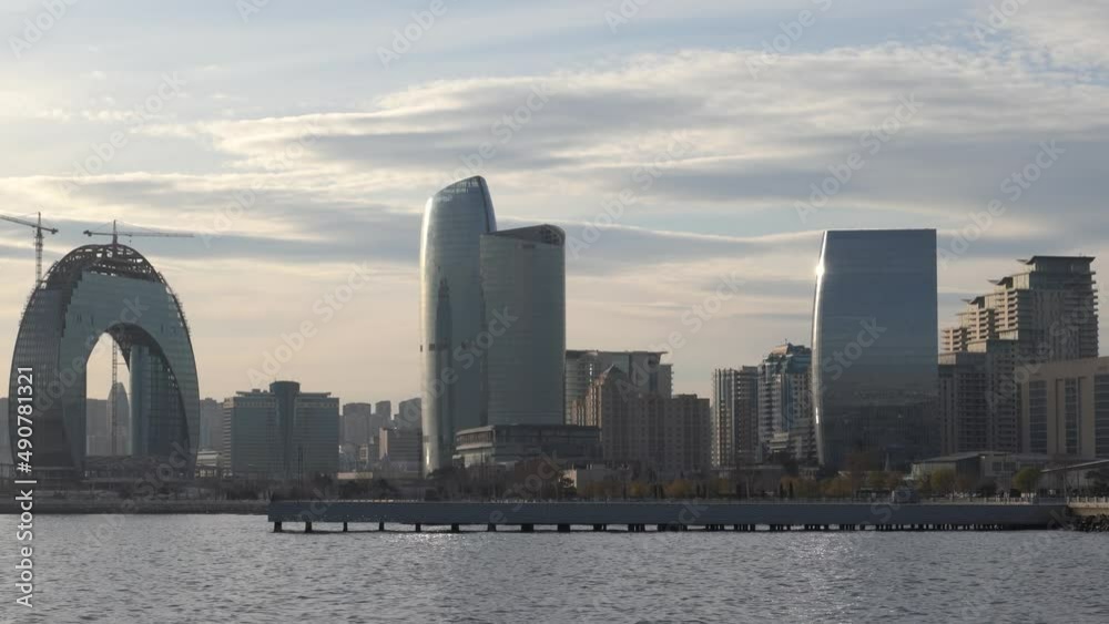 Baku, Azerbaijan - January 03 2022- Panoramic view of Baku city skyline from the Caspian Sea. Glass building under construction among Caspian seaside. Baku, Azerbaijan - January 03 2022- Panoramic view of Baku city skyline from the Caspian Sea. Glass building under construction among Caspian seaside.