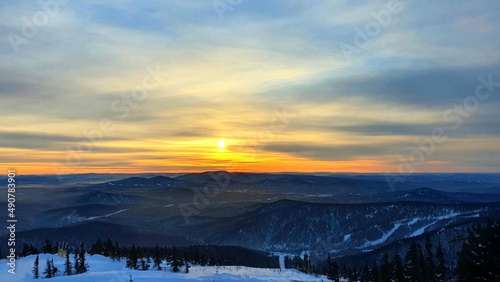 Sunset in the mountains in winter. Fantastic evening winter landscape. Dramatic overcast sky. Creative college. The world of beauty.