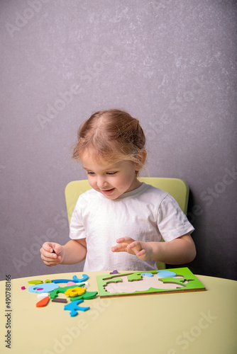 a little girl collects a puzzle