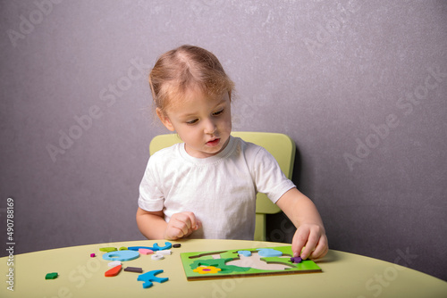 a little girl collects a puzzle