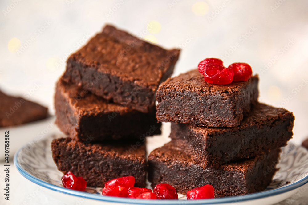 Plate with pieces of delicious chocolate brownie on light background, closeup Plate with pieces of delicious chocolate brownie on light background, closeup