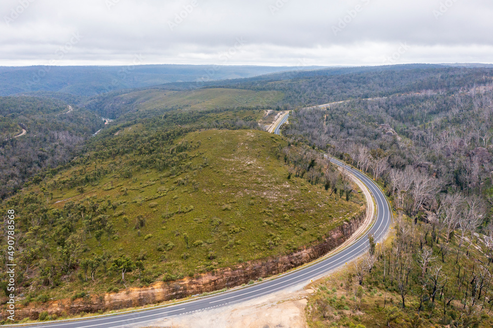 Drone aerial photograph of a highway running through a forest in regional Australia.