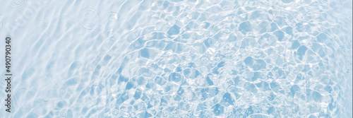 Banner of blue water  clean and transparent background  surface with vibrations from drops  flat lay