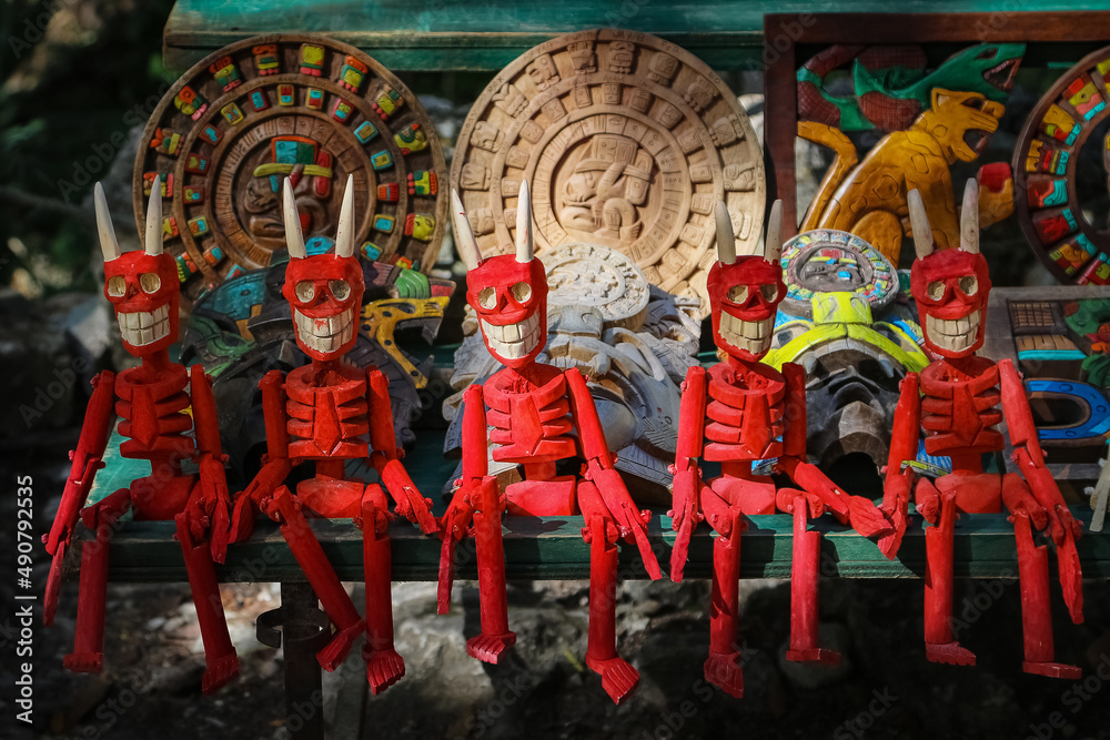 Wooden red figurines of skeletons. Traditional Mexican souvenirs.