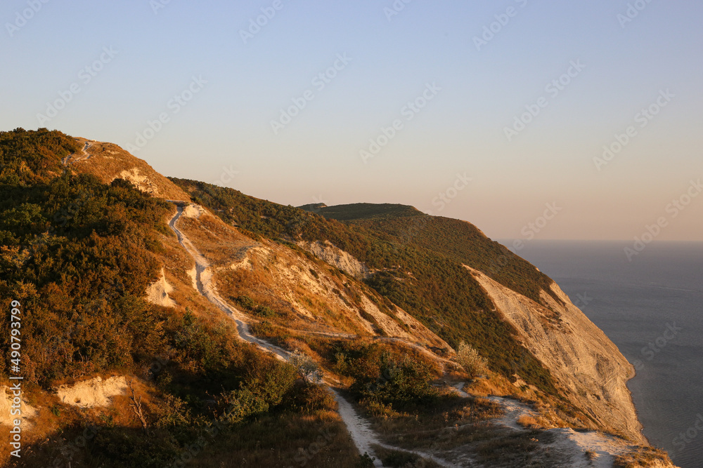 Rocky mountains with landscape island vegetation for tourists along the sea at sunset overlooking the horizon