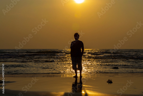 Golden Sunset by the sea with a human silhouette  facing the sun