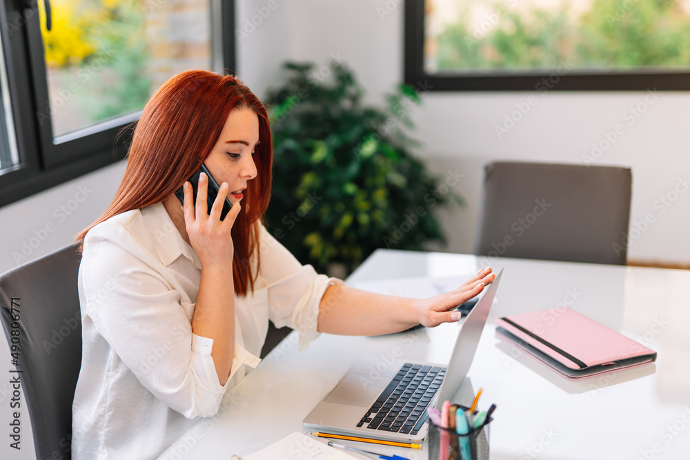 Young girl talking on mobile phone while working at home Young girl talking on mobile phone while working at home