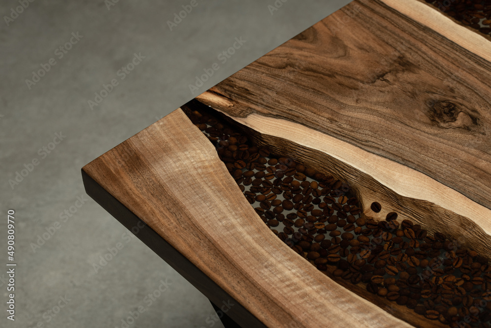 Expensive vintage furniture. The table is covered with epoxy resin and  varnished. Luxury quality wood processing. A transparent river of epoxy  resin in a slab of wood with coffee beans. Stock Photo
