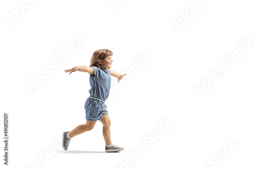 Full length profile shot of a happy little girl running and spreading arms