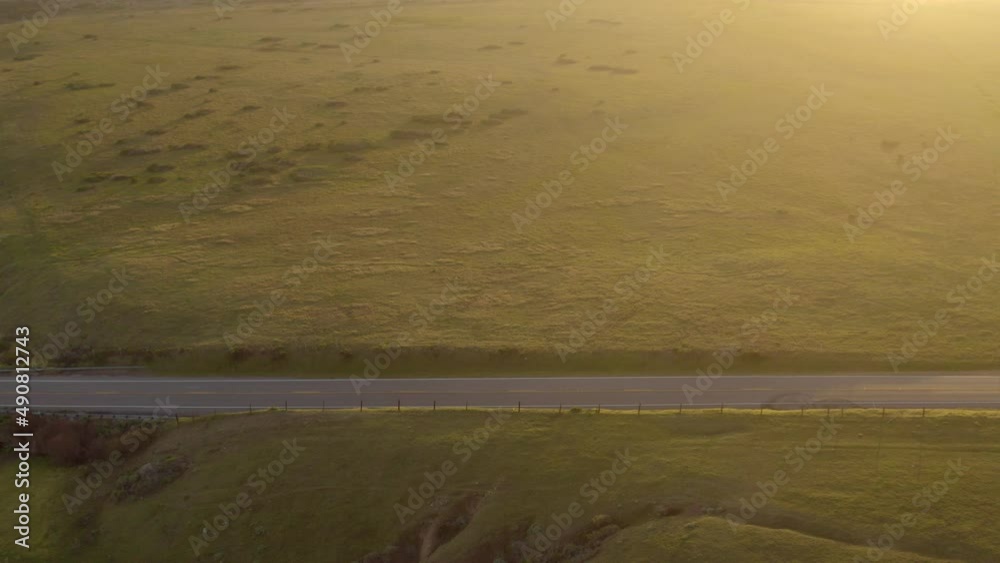 empty rural road at sunset. A narrow road divides two sunflower fields. Flying over a narrow road. A rural road to the golden summer sunset. empty rural road at sunset. A narrow road divides two sunflower fields. Flying over a narrow road. A rural road to the golden summer sunset.