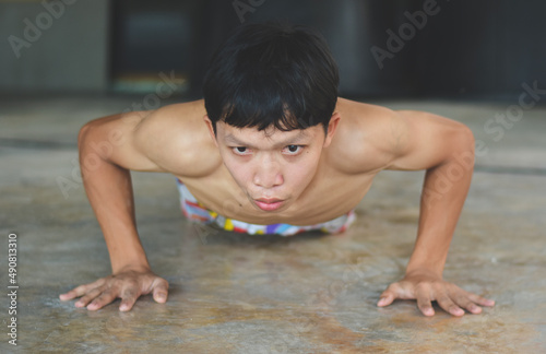 Young Asian men are exercising by doing push-up moves to build healthy and healthy muscles.