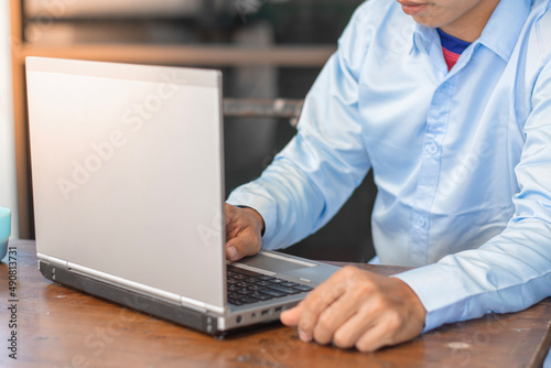 Young man working on a laptop at home, Technology & Business Concepts.