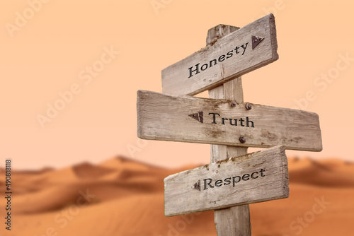 honesty truth respect text quote on wooden signpost outdoors in dry desert sand dune scenery. photo