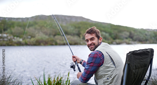Getting in some me-time. Portrait of a handsome young man fishing by a lake.