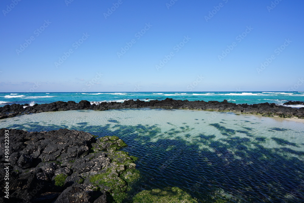 clear shoaling beach with rocks