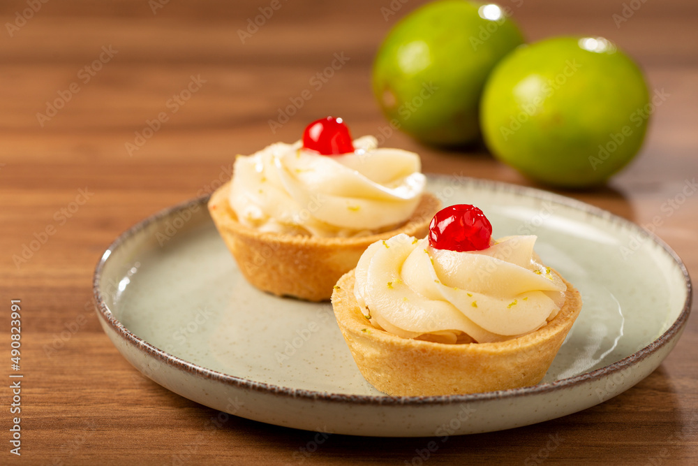 Lemon tartlets decorated with cherry.
