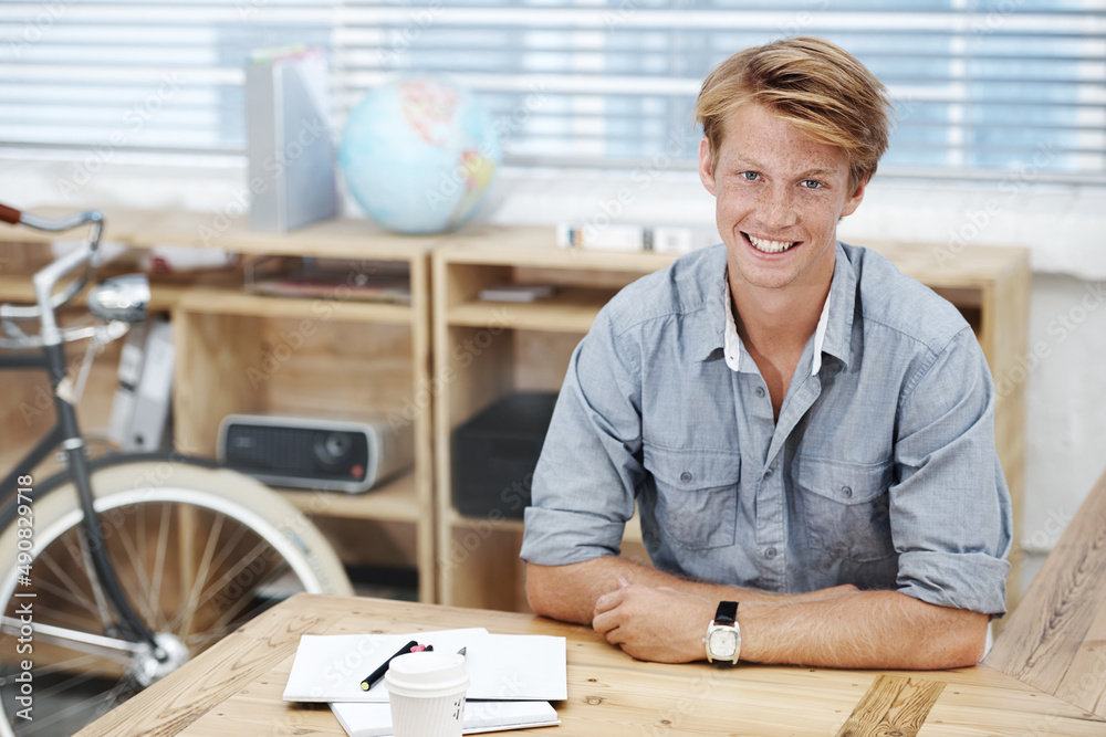© Anne B/peopleimages.com - Happy and confident in the office. Portrait of a young designer sitting in his office.
