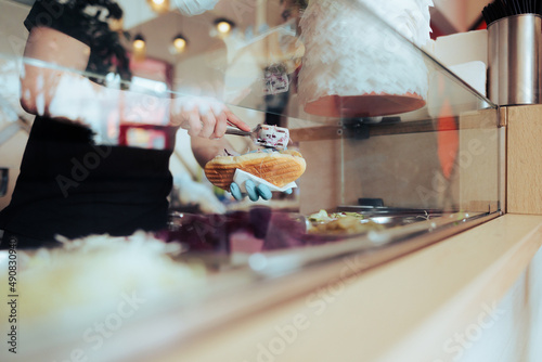 Fast Food Vendor Assembling a Sandwich in front of the Customer