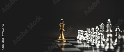 Close-up king chess standing first on chess board concepts challenge or battle fighting of business team and leadership strategy and organization risk management or team player. photo
