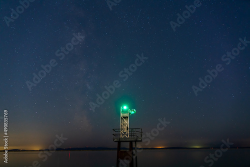 lighthouse in front of the galaxy sky