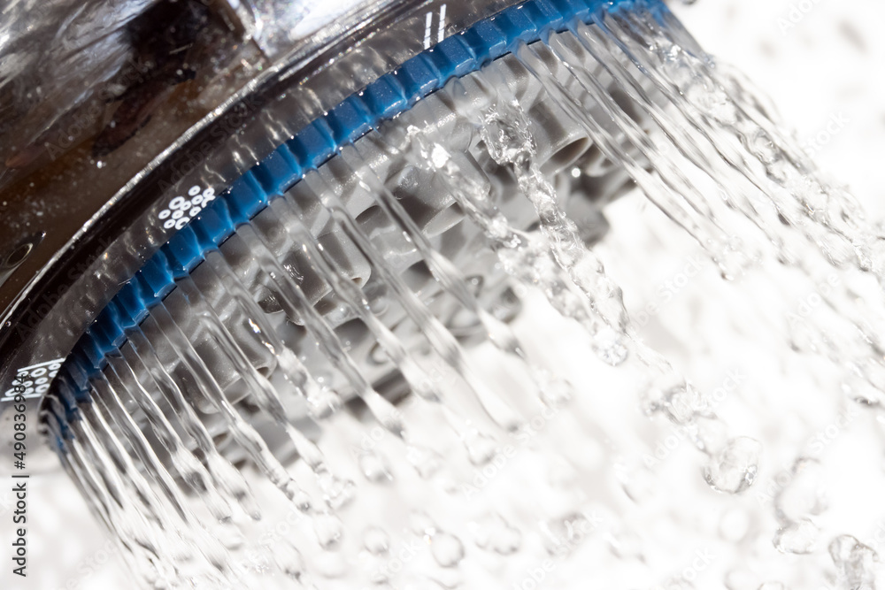 The water drops running from the shower head, close up view. The water drops running from the shower head, close up view.