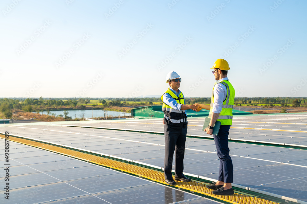 Professional engineer using drone and digital tablet maintaining solar cell panels together on building rooftop. Technician working on ecological solar farm. Renewable clean energy technology concept Professional engineer using drone and digital tablet maintaining solar cell panels together on building rooftop. Technician working on ecological solar farm. Renewable clean energy technology concept