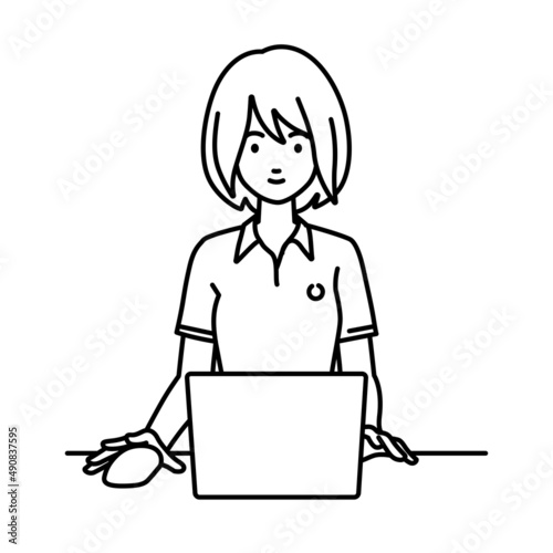 デスクで座ってPCを使っているポロシャツの女性