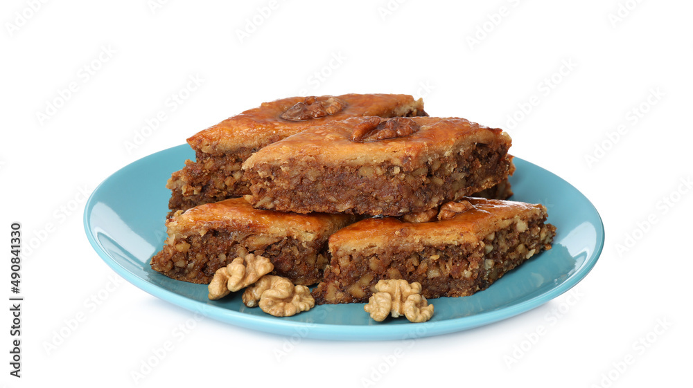 Plate of delicious honey baklava with walnuts on white background