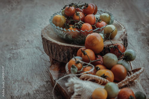 Group of Colorful variety of Fresh wild tomatoes (Mini Cherry Tomatos) on old wooden board background. Top view, Selective focus.