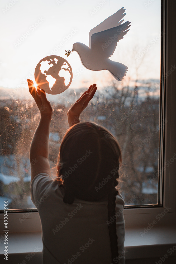 child stretches his hands sunlight outside window flying dove world with branch forces globe. concept peace world, no war, ecology - obrazy, fototapety, plakaty 