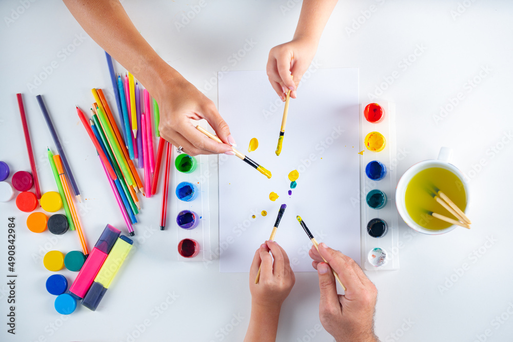 Fathers, mothers hands with children hands painting and drawing. Artist painting, drawing art. Top view. Fathers, mothers hands with children hands painting and drawing. Artist painting, drawing art. Top view.