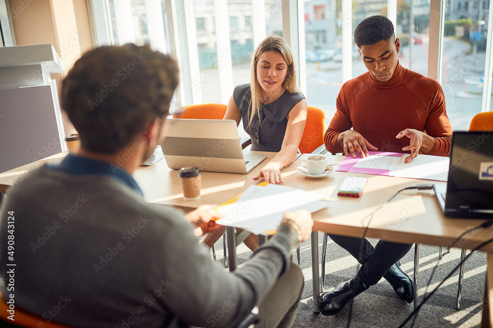 meeting of smiling diverse business team analyzing financial data