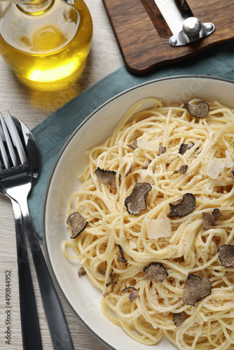 Tasty spaghetti with truffle served on wooden table, flat lay