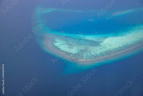 Tropical islands and atolls in Maldives from aerial view. Famous travel destination and luxury vacation or summer holiday concept. Aerial landscape of blue sea and resorts, hotels. Gorgeous nature