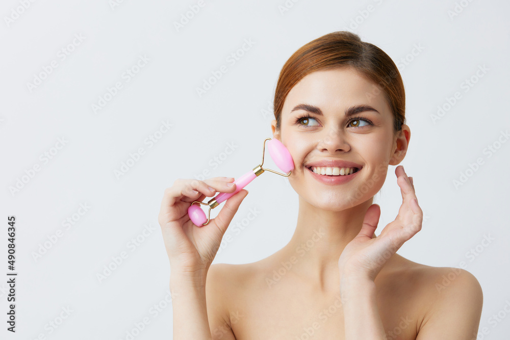 young woman jade face massager wrinkle smoothing smile light background young woman jade face massager wrinkle smoothing smile light background
