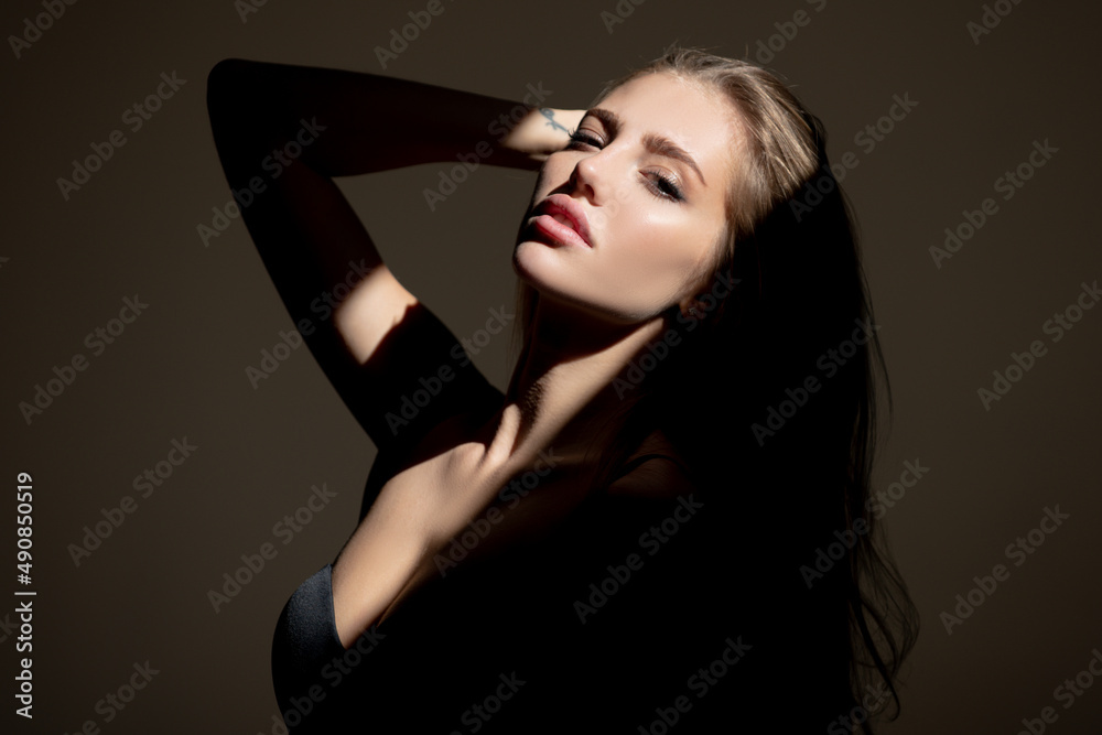 Fototapeta premium Beauty portrait of beautiful female model, fashion glamour portrait. Beauty female face. Sensual girl with art shadow light.