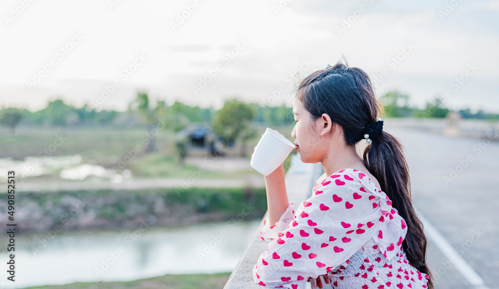 Close-up of a smiling woman sipping coffee from a white mug. Close-up of a smiling woman sipping coffee from a white mug.