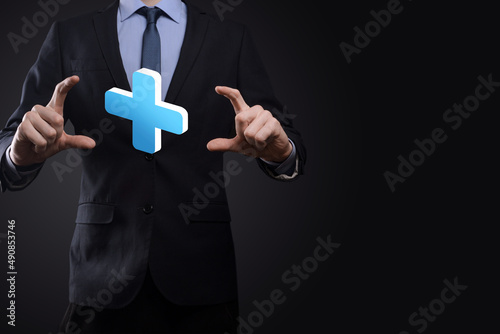 Businessman hold 3D plus icon, man hold in hand offer positive thing such as profit, benefits, development, CSR represented by plus sign.The hand shows the plus sign