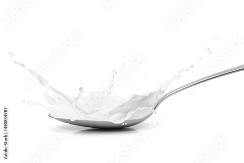 Spoon with milk splash isolated on white background.