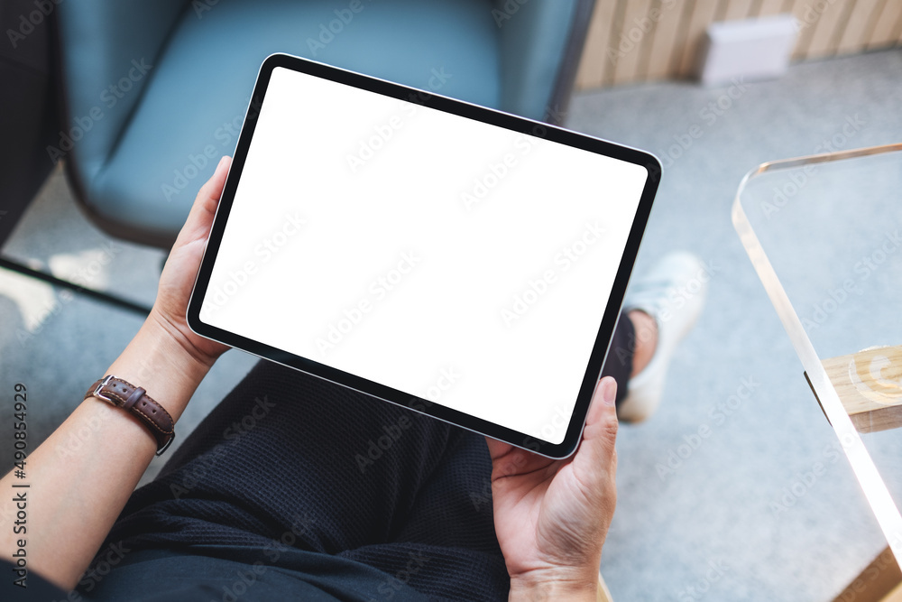 Top view mockup image of a woman holding digital tablet with blank white desktop screen in cafe - obrazy, fototapety, plakaty 