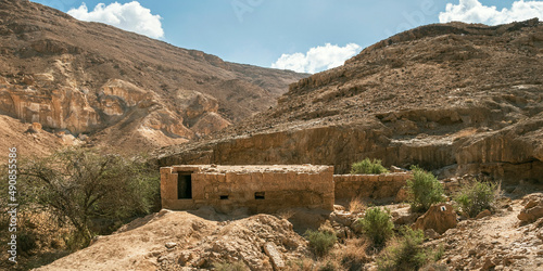 Bor Nekarot a rare above ground Nabatean Cistern southeast of the Makhtesh Ramon crater in Israel with a rocky desert hillside and partly cloudy sky in the background photo