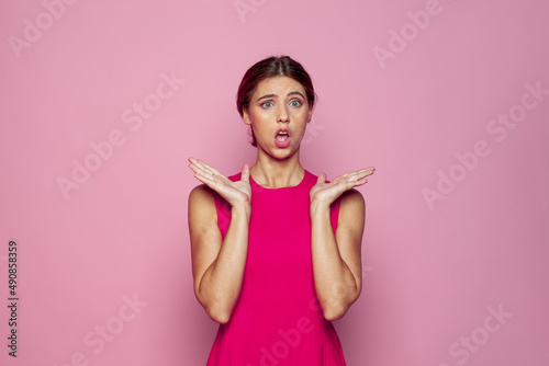 Shocked woman on pink background. Scared horrified emotion