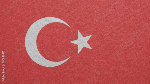 Turkey Flag outline on cardboard surface. Paper texture with cellulose fibers. Paperboard wallpaper or background. The official symbol of Turkey. Faded pale color