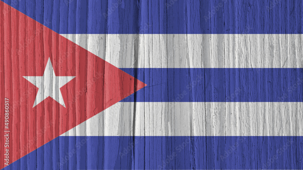 Cuban flag on a dry wooden surface. Natural background or backdrop made of old wood. The official symbol of Cuba. Solar lighting with hard shadows. Faded pale color
