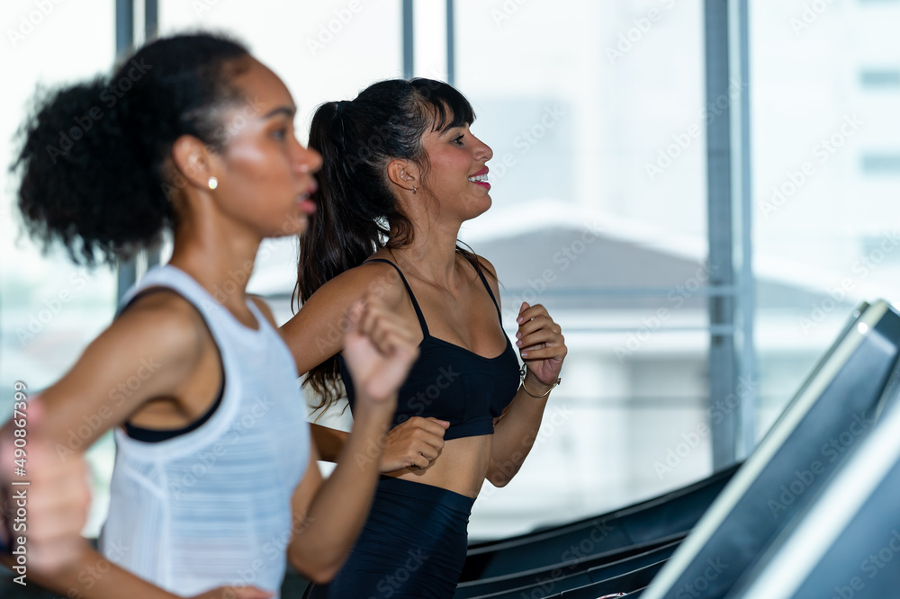 Healthy athletic woman in sportswear jogging workout exercise on treadmill at fitness gym. Wellness female do sport training cardio on running machine at sport club. Health care motivation concept Healthy athletic woman in sportswear jogging workout exercise on treadmill at fitness gym. Wellness female do sport training cardio on running machine at sport club. Health care motivation concept