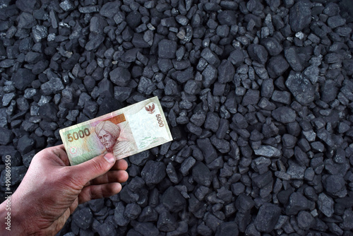 Indonesian rupiah currency showed on coal of mine deposit mineral resources background