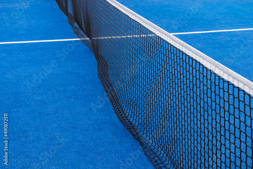 Blue paddle tennis net and court field background © Vic
