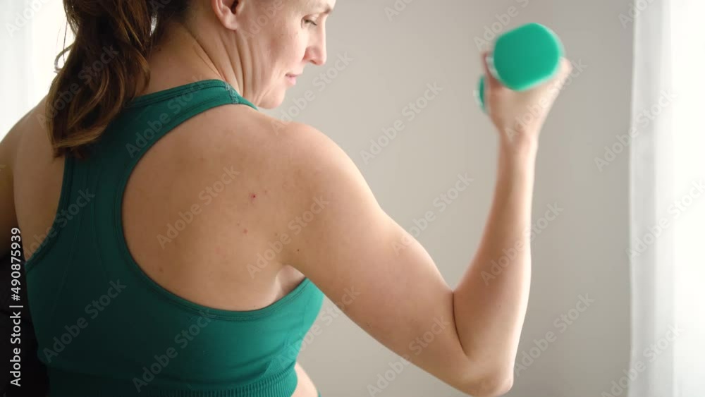 A pregnant woman is exercising with dumbbells. Concept of a healthy lifestyle during pregnancy. Sports activities before the birth of baby. Useful exercises, fitness for health of the expectant mother A pregnant woman is exercising with dumbbells. Concept of a healthy lifestyle during pregnancy. Sports activities before the birth of baby. Useful exercises, fitness for health of the expectant mother