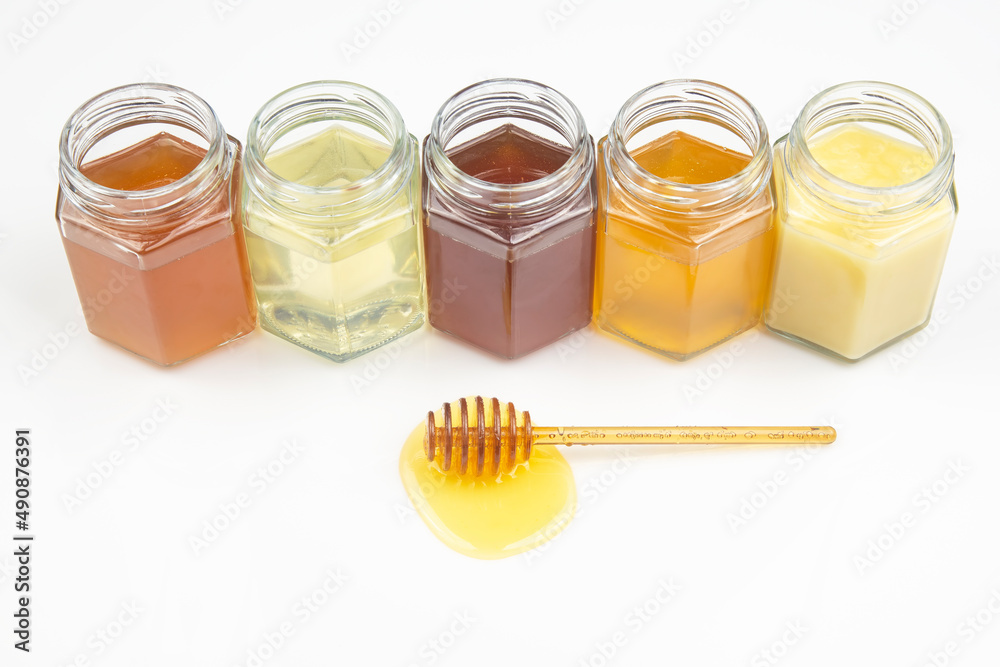 spoon with fresh honey and pollen on the background of jars with different types of honey. organic vitamin food spoon with fresh honey and pollen on the background of jars with different types of honey. organic vitamin food