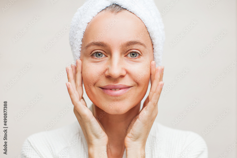 portrait of gorgeous happy middle age woman looking at mirror touching her skin portrait of gorgeous happy middle age woman looking at mirror touching her skin